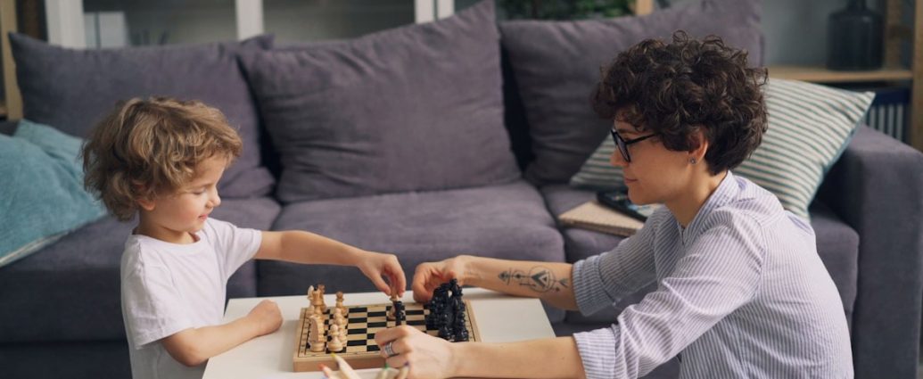a boy and a boy playing chess on a coffee table
