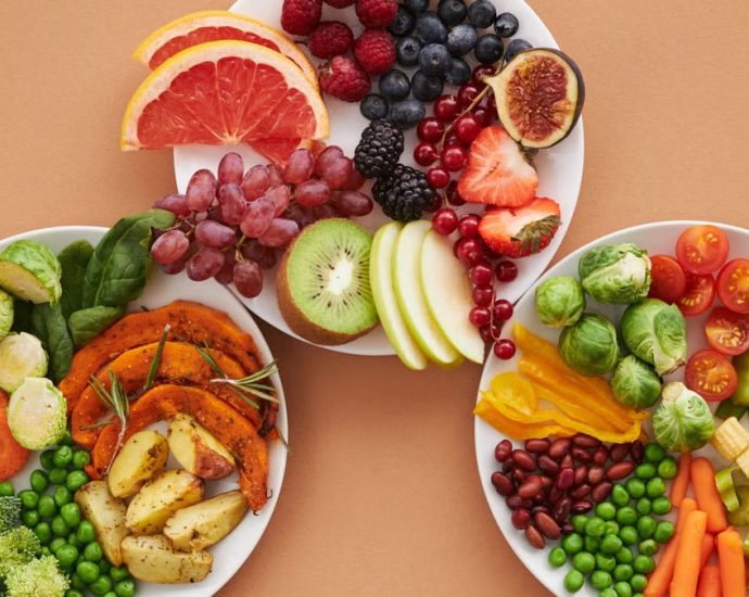 Top view of vibrant plates of fresh fruits and vegetables, perfect for a healthy lifestyle.